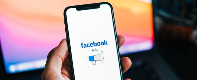 Mão segurando celular com aplicativo do Facebook Ads abrindo
