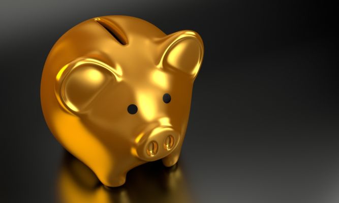 Foto de um cofre de dinheiro dourado em formato de porco. Imagem ilustrativa para texto como abrir uma franquia.