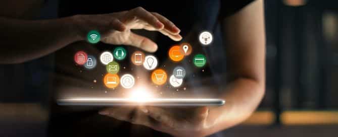 Um homem segura um tablet que projeta ícones relacionados a internet e o marketing