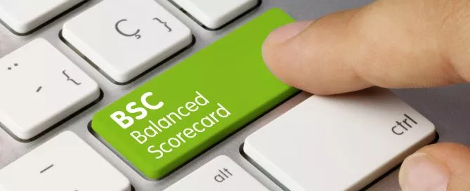 Imagem de um dedo humano clicando em uma tecla de computador com o termo "Balanced Scorecard" escrito.
