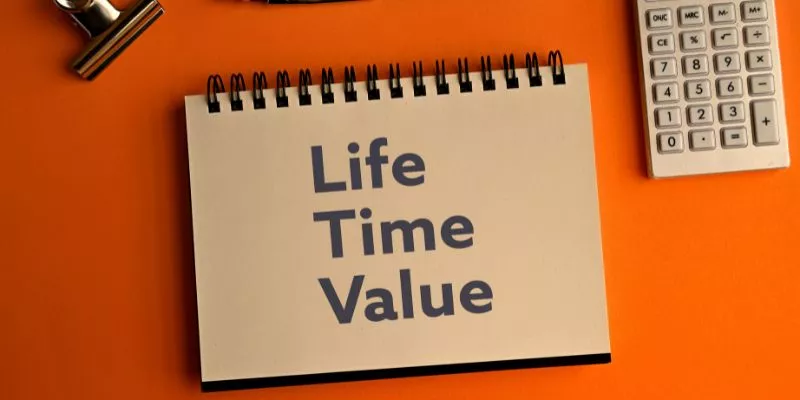 Caderno marrom com o termo "Lifetime Value" escrito em letras grandes