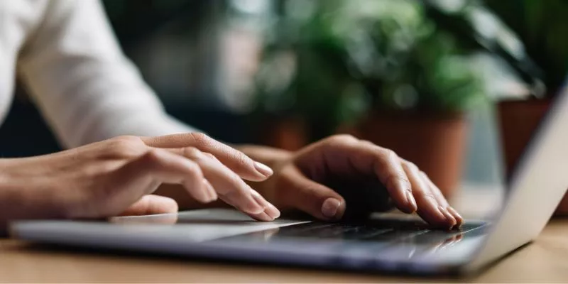 Mãos humanas digitando em um teclado de computador