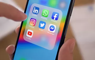 A foto foca na tela de um celular onde estão os ícones do LinkedIn, WhatsApp, Facebook, Instagram, Twitter, Messenger e Youtube.