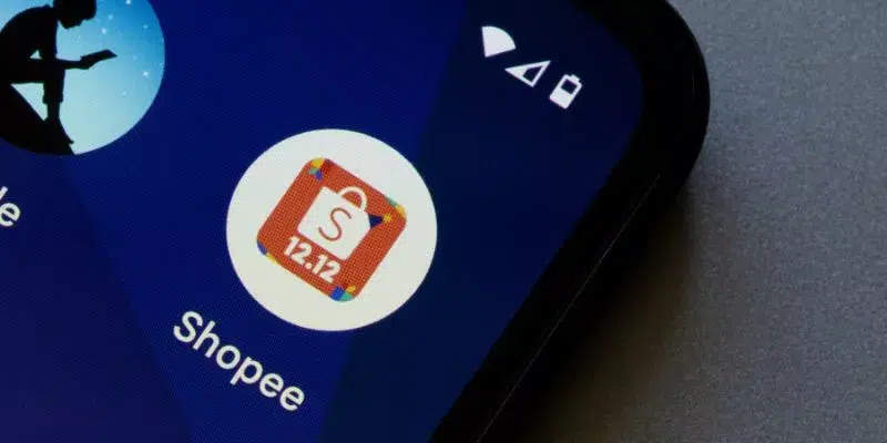 A imagem foca na tela de um celular onde está o ícone do aplicativo da Shopee.