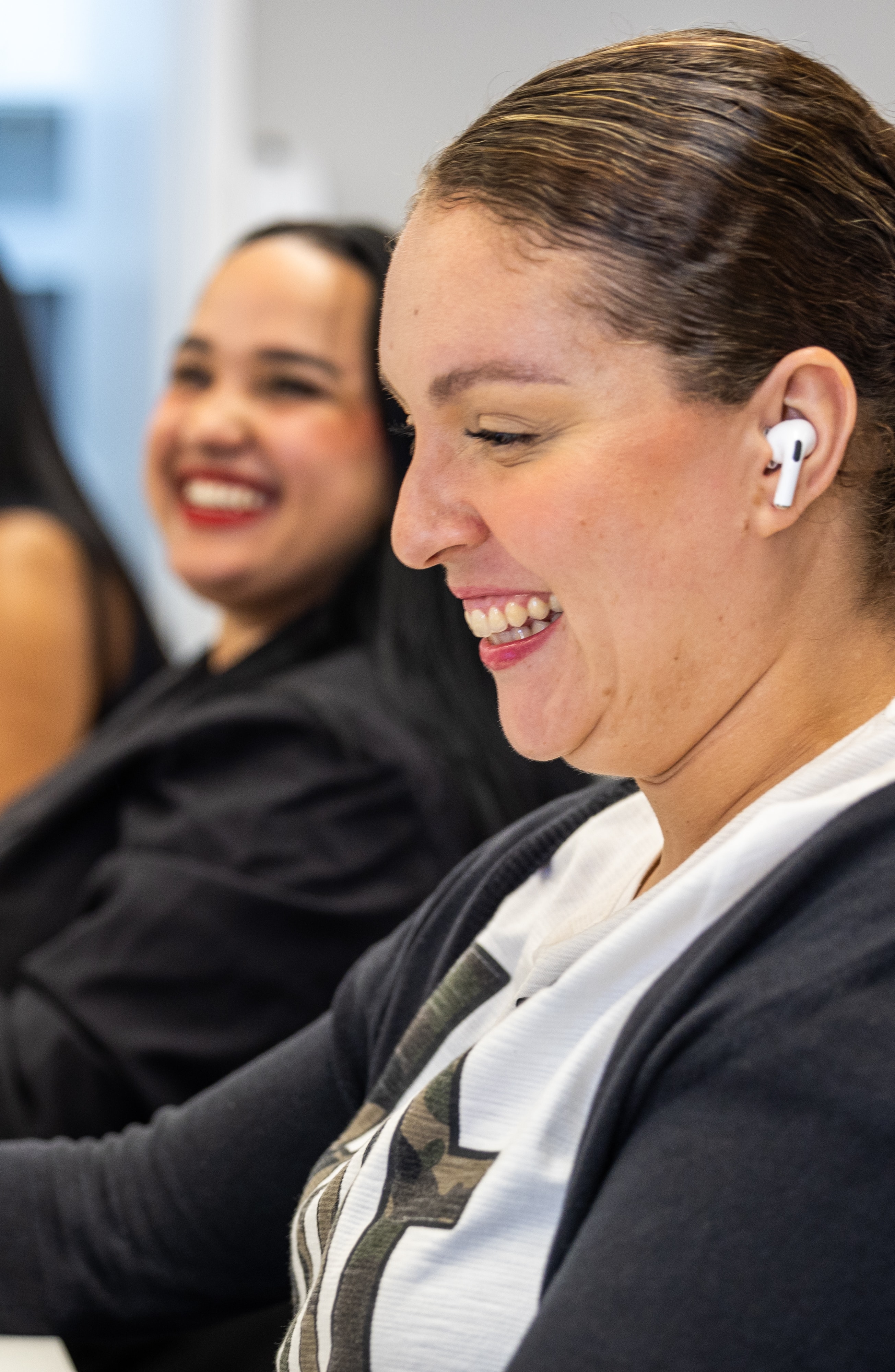 Duas funcionárias a partilhar um momento de bom humor durante uma sessão de trabalho ou treino.